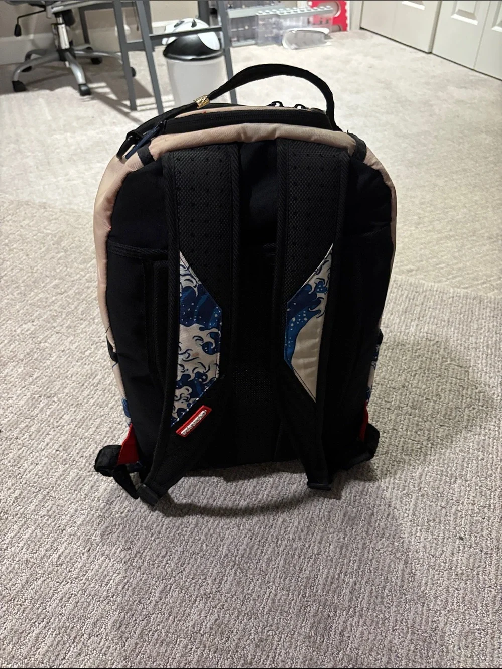 Sprayground Beige Backpack with Blue Wave and Surfing Cartoon